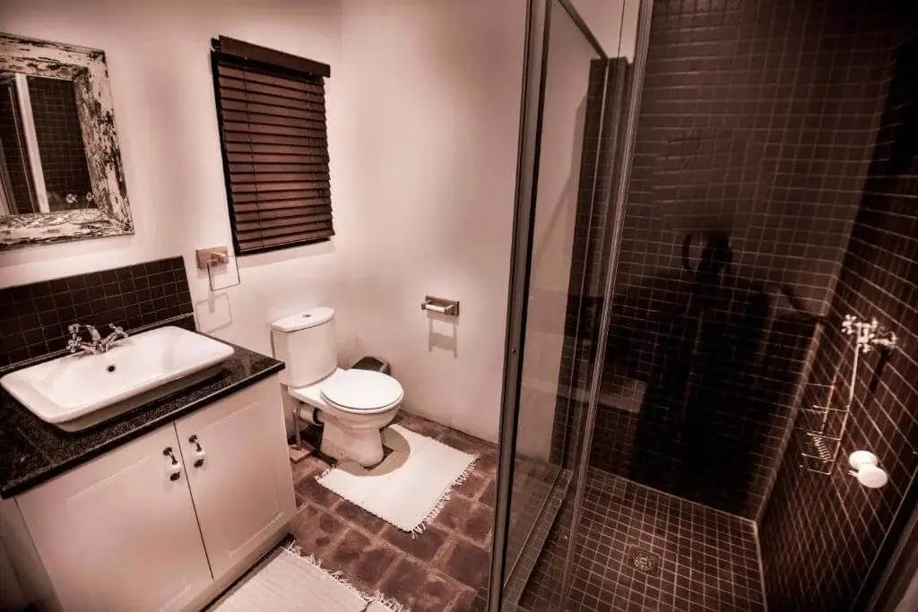 A modern bathroom with a separate shower area, toilet, and sink vanity.